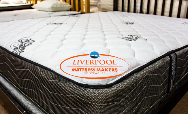 Mattress with 'Liverpool Mattress Makers' logo on a bed in a bedroom setting